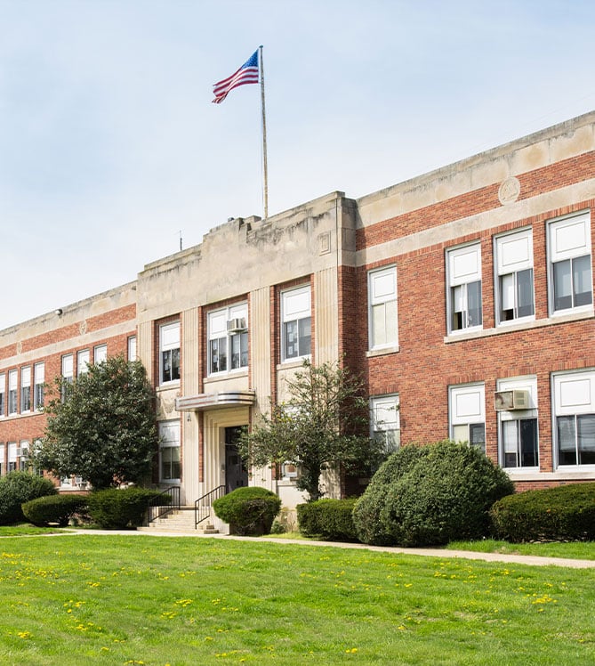Historic school building with an American flag on top.