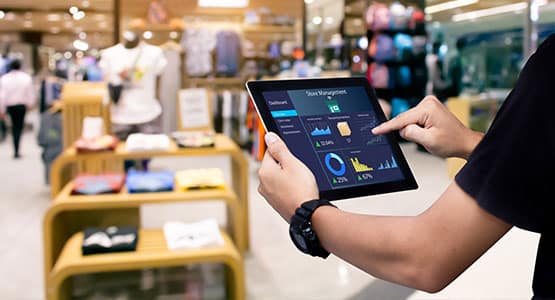 Person using tablet to view store analytics in a retail environment.