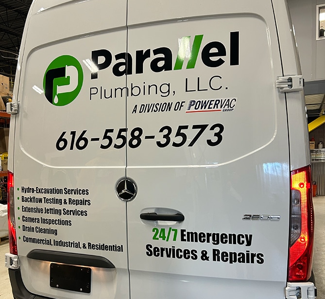 Back of a van with Parallel Plumbing LLC logo, contact details, and list of services offered.