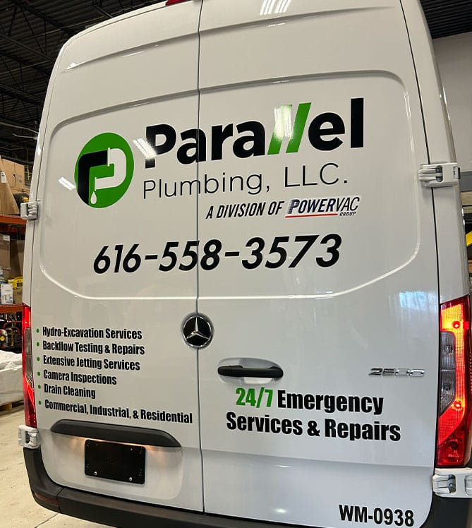 Parallel Plumbing LLC van with contact info and services listed on the back.